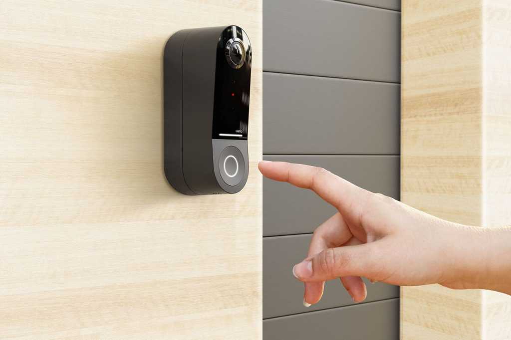 Finger about to press the Wemo Smart Video Doorbell